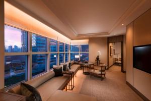 a living room with a couch and a large window at Conrad Centennial Singapore in Singapore