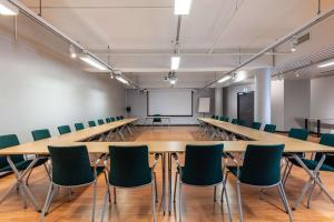 une salle de conférence avec une grande table et des chaises dans l'établissement Scandic Rovaniemi City, à Rovaniemi