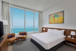 Giường trong phòng chung tại Aleph Doha Residences, Curio Collection By Hilton