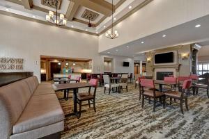a hotel lobby with tables and chairs and a fireplace at Homewood Suites by Hilton Albuquerque Airport in Albuquerque
