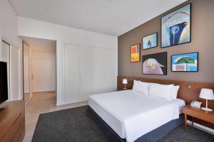 Giường trong phòng chung tại Aleph Doha Residences, Curio Collection By Hilton
