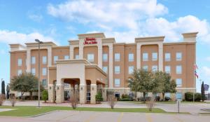 un gran edificio marrón con un letrero rojo. en Hampton Inn & Suites Abilene I-20 en Abilene