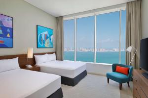 Giường trong phòng chung tại Aleph Doha Residences, Curio Collection By Hilton