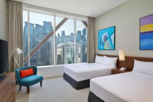 Giường trong phòng chung tại Aleph Doha Residences, Curio Collection By Hilton