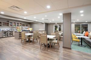 um restaurante com mesas e cadeiras e uma cozinha em Homewood Suites by Hilton Albuquerque-Journal Center em Albuquerque