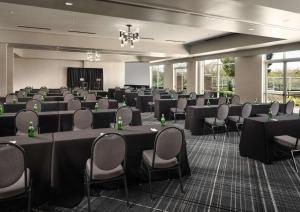 a conference room with tables and chairs and a screen at Hilton Charlotte Airport Hotel in Charlotte +56 photos