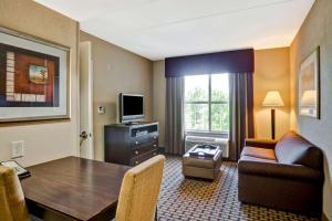 Habitación de hotel con mesa y sala de estar. en Homewood Suites by Hilton Bel Air, en Riverside