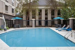 a large swimming pool with chairs and umbrellas at Hampton Inn & Suites Alpharetta-Windward in Alpharetta