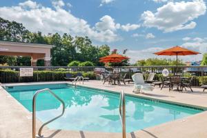 a swimming pool with chairs and tables and umbrellas at Hampton Inn Adel in Adel