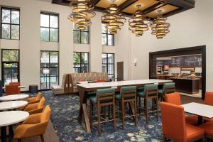 una sala da pranzo con un grande tavolo e sedie di Hampton Inn & Suites Alpharetta-Windward ad Alpharetta