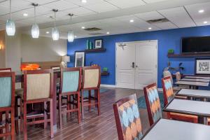 Hampton Inn Adel في آدل: غرفة طعام بجدران زرقاء وطاولات وكراسي