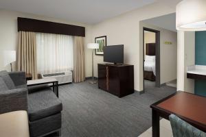 a living room with a couch and a television in a hotel room at Hampton Inn & Suites Alpharetta-Windward in Alpharetta