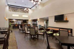 a dining room with tables and chairs and a tv at Hampton Inn & Suites Birmingham/280 East-Eagle Point in Hoover