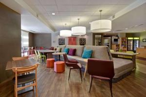 a waiting room with a couch and tables and chairs at Home2 Suites by Hilton Nashville Vanderbilt, TN in Nashville