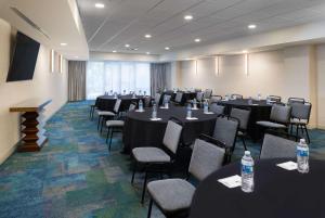 Home2 Suites by Hilton Nashville Vanderbilt, TN في ناشفيل: قاعة المؤتمرات مع الطاولات والكراسي مع زجاجات المياه