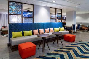 a lobby with a couch with colorful pillows and tables at Hampton Inn Denver-International Airport in Denver