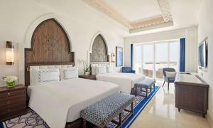 Una cama o camas en una habitación de Hilton Salwa Beach Resort and Villas
