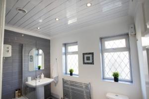 a bathroom with a sink and a mirror at Rawmarsh House, Rotherham for contractors & Families, off-road parking, high speed wifi in Rotherham +75 photos