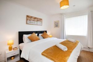 a bedroom with a large white bed with orange pillows at Rawmarsh House, Rotherham for contractors & Families, off-road parking, high speed wifi in Rotherham