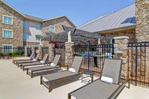 a row of chaise lounge chairs in front of a building at Homewood Suites by Hilton Oklahoma City-West in Oklahoma City