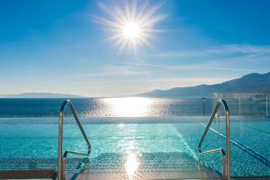 a swimming pool with a view of the water at Hilton Rijeka Costabella Beach Resort And Spa in Rijeka