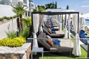 a row of chaise lounges on the beach at Hilton Rijeka Costabella Beach Resort And Spa in Rijeka