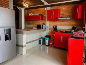 a kitchen with red cabinets and a white refrigerator at Depto Nuevo cerca del foro sol "Andy" in Mexico City +24 photos