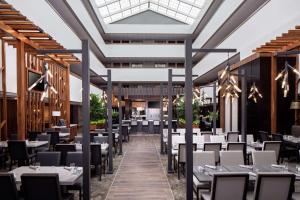 um restaurante com mesas e cadeiras e uma clarabóia em Embassy Suites by Hilton Boston Marlborough em Marlborough