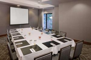 a conference room with a large white table and a screen at Embassy Suites by Hilton Boston Marlborough in Marlborough +28 photos