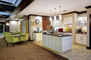 a kitchen with white cabinets and a table and chairs at Homewood Suites by Hilton Atlanta-Galleria/Cumberland in Atlanta