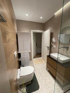 ein Bad mit einem WC, einem Waschbecken und einer Dusche in der Unterkunft Downtown Studio Apartments in Tirana