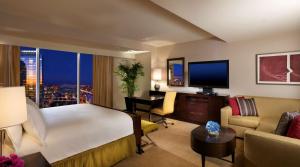 a hotel room with a large bed and a desk with a television at Hilton Americas - Houston in Houston