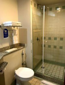 y baño con aseo y ducha acristalada. en Flat Live Lodge, en São Paulo
