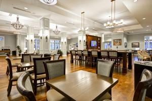 チャールストンにあるHampton Inn & Suites Charleston Airportのテーブルと椅子のあるレストラン、バー