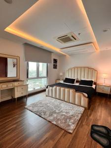 Luxurious Appartment in GOLDCREST DHA Lahore في لاهور: غرفة نوم كبيرة مع سرير كبير وسجادة