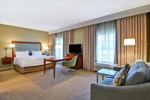 Habitación de hotel con cama, escritorio y sofá en Hampton Inn & Suites Charleston Airport, en Charleston