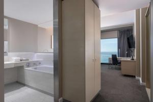 baño con bañera y lavabo y escritorio en Radisson Blu Hotel, Port Elizabeth en Puerto Elizabeth