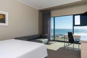a hotel room with a bed and a view of the ocean at Radisson Blu Hotel, Port Elizabeth in Port Elizabeth