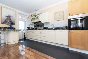 a large kitchen with white cabinets and a large appliance at Seaview Retreat - South Shields in South Shields