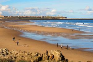 a group of people walking on the beach at Seaview Retreat - South Shields in South Shields