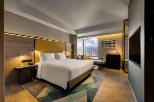 una camera d'albergo con un letto e una grande finestra di Hotel Resonance Taipei, Tapestry Collection by Hilton a Taipei