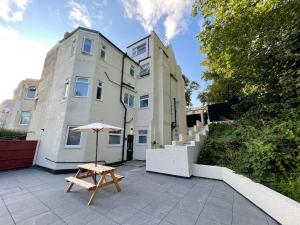 a patio with an umbrella and a table in front of a building at West Midlands-2 Double Bed Room Apartment in Dudley