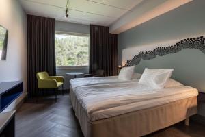 a hotel room with a large bed and a window at Scandic Rukahovi in Ruka