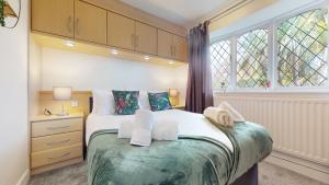 a bedroom with a bed and a window at Charming 3 Bed Bungalow Parking & Wifi Business and Leisure by Jesswood Properties in Hinckley