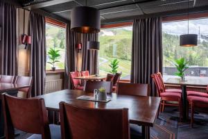 a dining room with tables and chairs and a large window at Scandic Rukahovi in Ruka