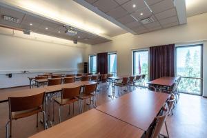 an empty classroom with tables and chairs and windows at Scandic Rukahovi in Ruka