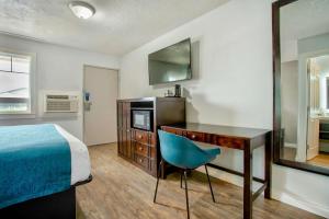 a bedroom with a desk and a bed and a desk and chair at Studio 6 Suites - Albany, OR in Albany