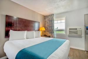 Un dormitorio con una cama grande y una ventana en Studio 6 Suites - Albany, OR, en Albany