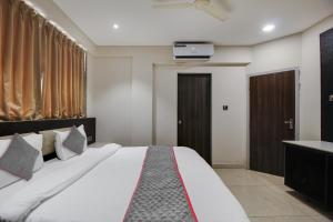 - une chambre avec un lit et une télévision murale dans l'établissement Collection O Avasa Grand, à Vieux-Goa