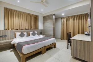 a bedroom with a bed and a desk in a room at Collection O Avasa Grand in Old Goa